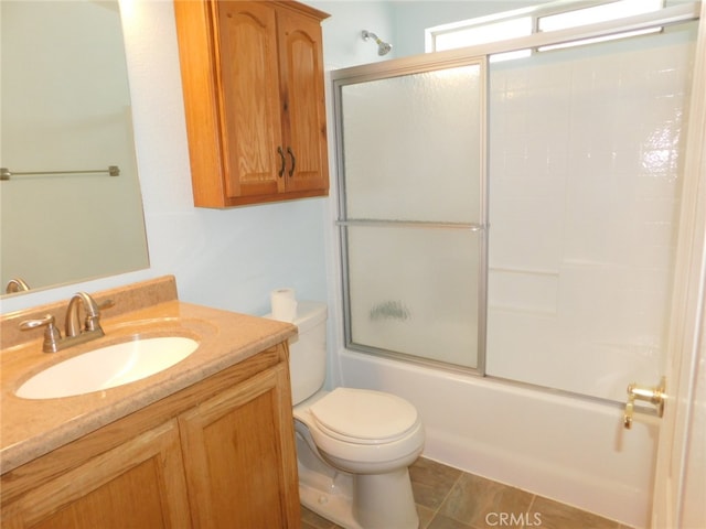 full bathroom with tile patterned floors, shower / bath combination with glass door, vanity, and toilet