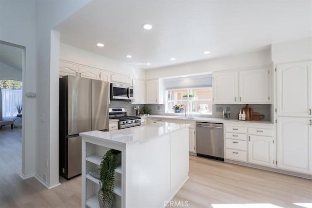 kitchen featuring decorative backsplash, white cabinetry, plenty of natural light, and stainless steel appliances