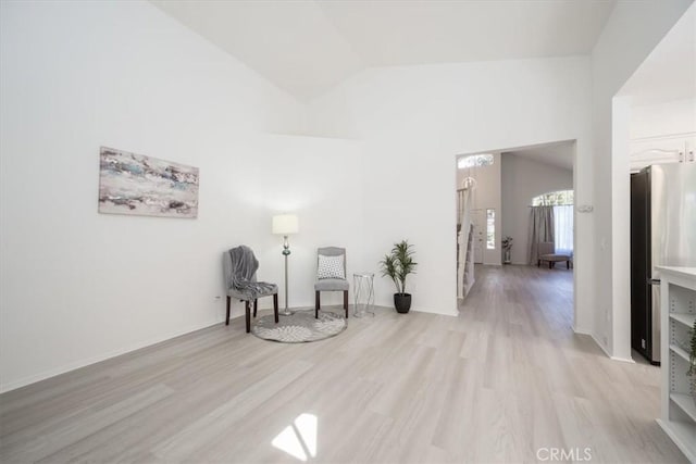 living area featuring light hardwood / wood-style floors and lofted ceiling