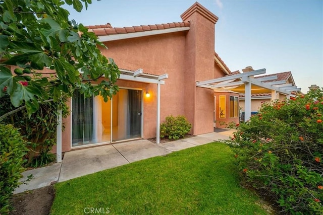 rear view of house featuring a lawn and a pergola