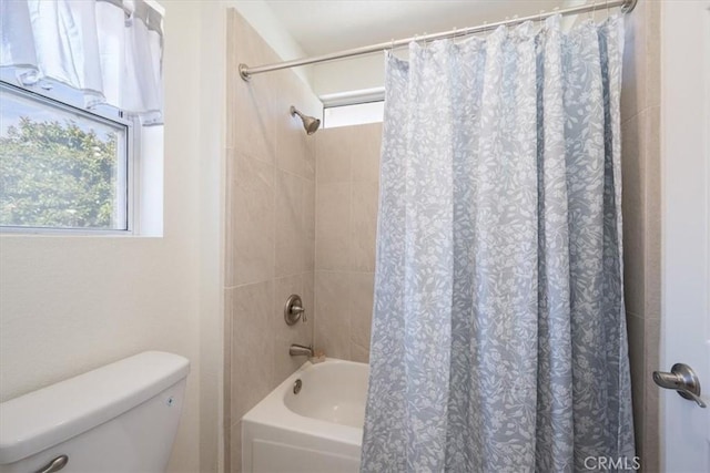 bathroom with shower / bathtub combination with curtain and toilet