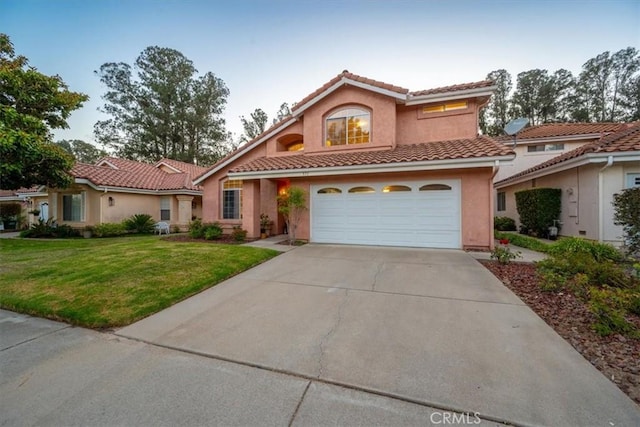 mediterranean / spanish-style home featuring a front yard and a garage