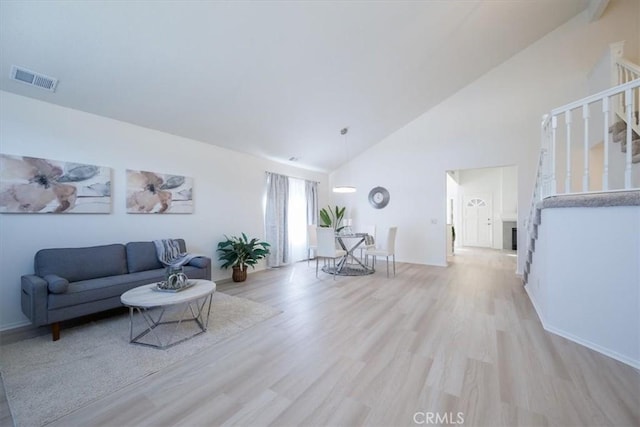 living room featuring light hardwood / wood-style flooring and high vaulted ceiling