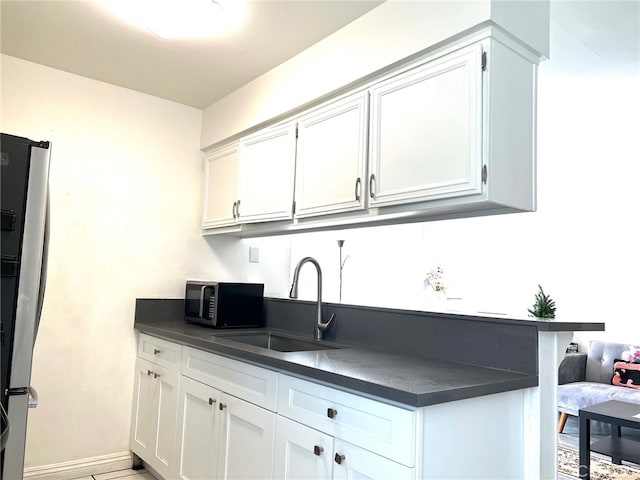 kitchen with appliances with stainless steel finishes, sink, and white cabinetry