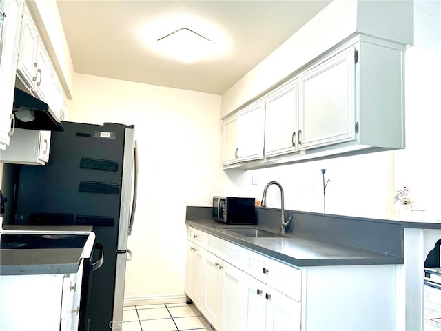 kitchen featuring white stove, sink, white cabinetry, fridge, and light tile patterned floors