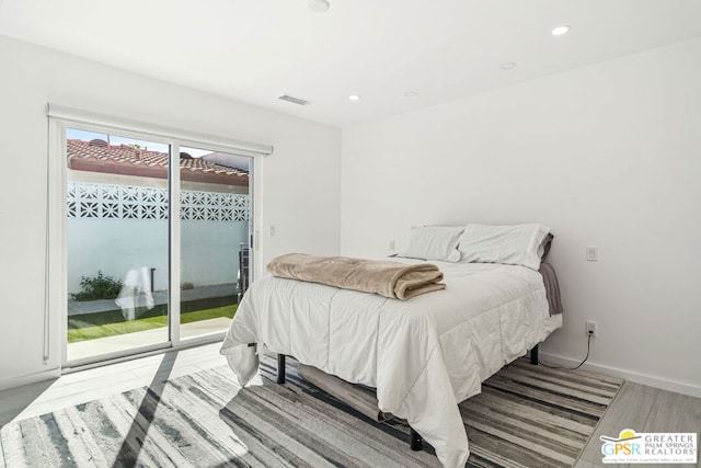 bedroom featuring access to exterior and hardwood / wood-style flooring