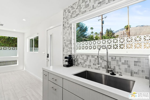 kitchen with a mountain view, tasteful backsplash, and sink