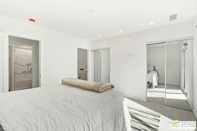 bedroom with wood-type flooring and connected bathroom