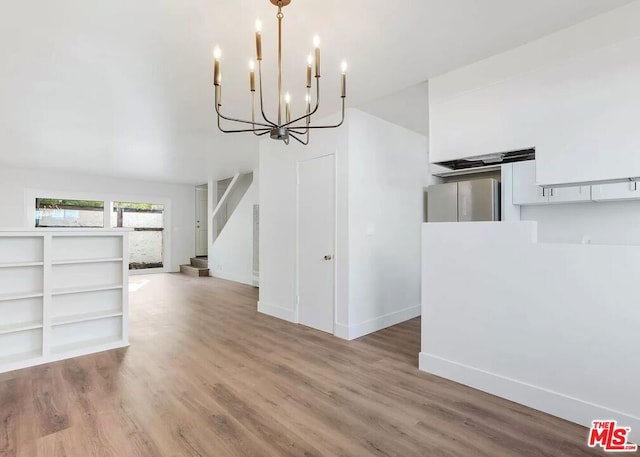 unfurnished dining area featuring hardwood / wood-style floors and a chandelier