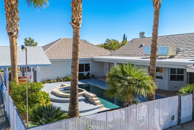 back of house featuring a pool with hot tub and a patio