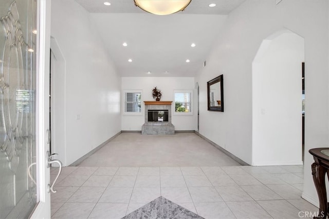 unfurnished living room with light tile patterned flooring and vaulted ceiling