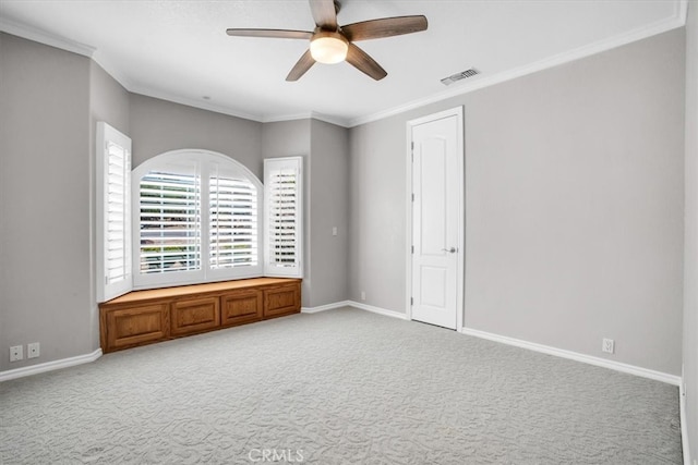 spare room featuring ceiling fan, ornamental molding, and carpet