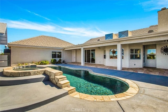 exterior space featuring a swimming pool with hot tub and a patio area