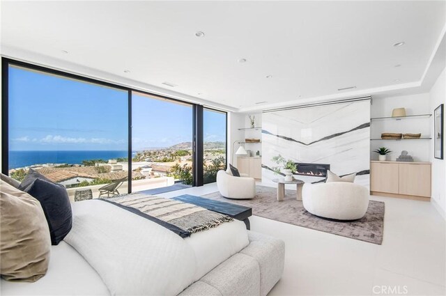 bedroom with a water view and expansive windows