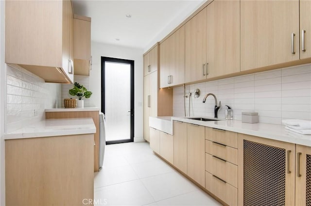 11 Seabreeze Ter, Dana Point, CA 92629 - kitchen with light brown cabinetry, a sink, backsplash, light stone countertops, and modern cabinets
