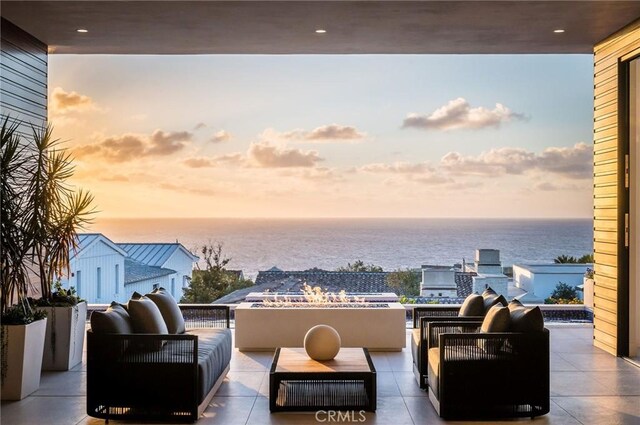 patio terrace at dusk featuring a water view