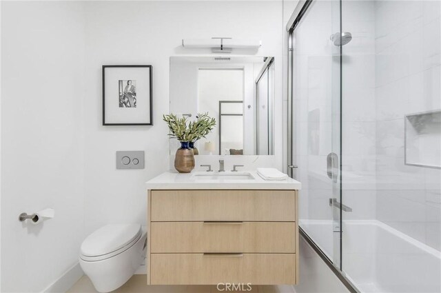 full bathroom featuring vanity, toilet, and bath / shower combo with glass door