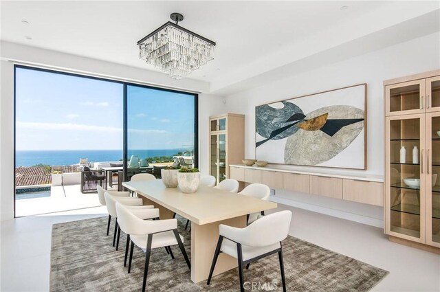 dining space with a water view and a chandelier