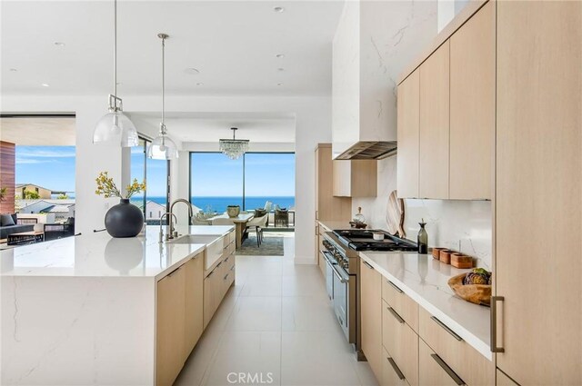 kitchen featuring light brown cabinets, plenty of natural light, and high end range