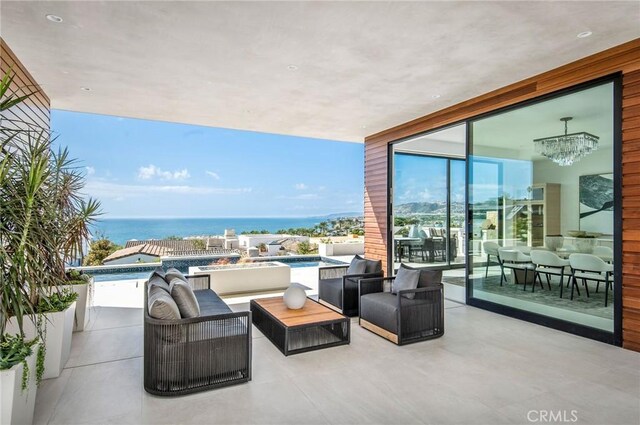 view of patio / terrace with a water view, outdoor lounge area, and a swimming pool with hot tub