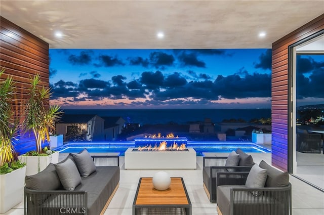 pool at dusk featuring outdoor lounge area and a patio area