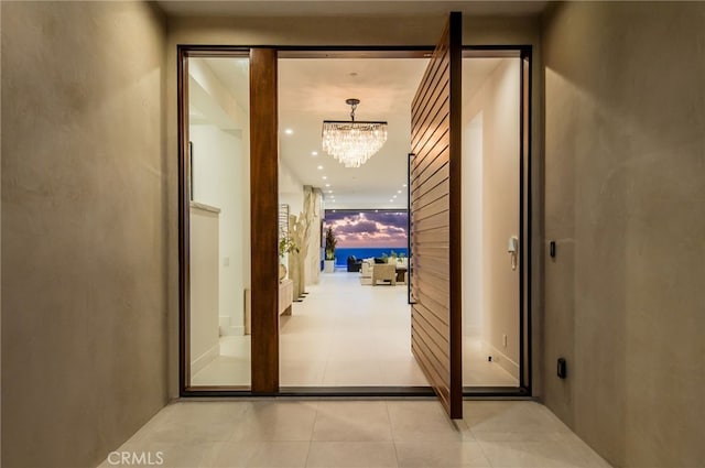 hallway featuring light tile patterned floors and a notable chandelier