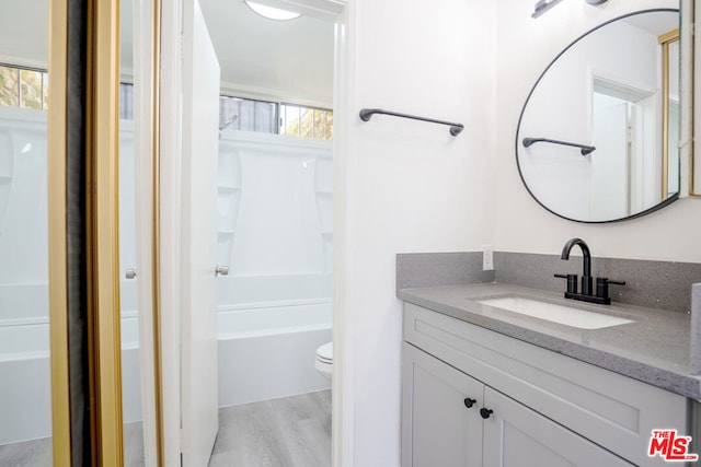 bathroom featuring wood-type flooring, vanity, and toilet