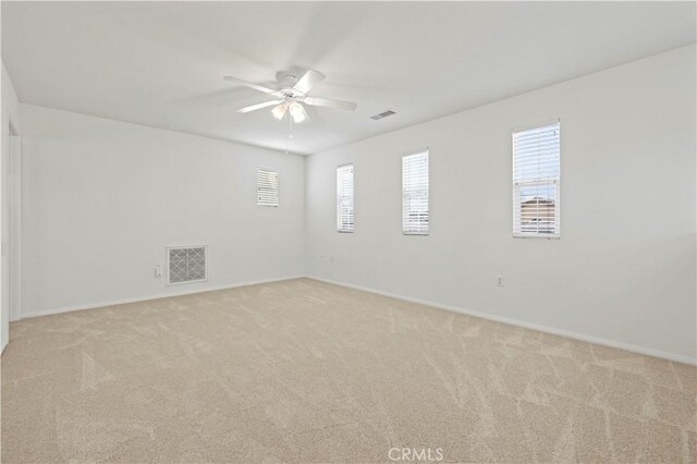 empty room featuring ceiling fan and light colored carpet