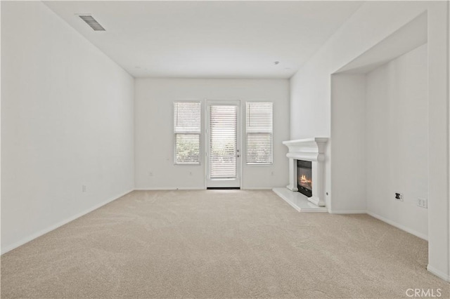 unfurnished living room featuring light colored carpet