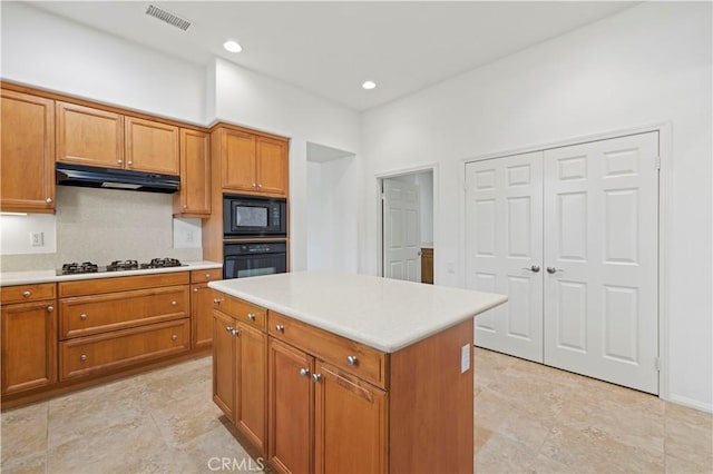 kitchen with tasteful backsplash, a kitchen island, and black appliances