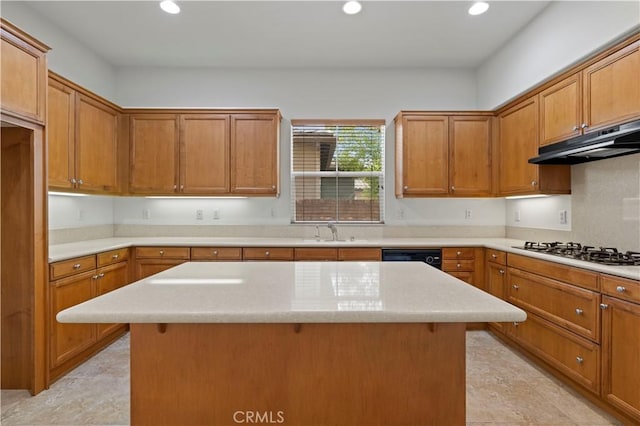 kitchen featuring a center island, sink, stainless steel gas cooktop, and a breakfast bar area