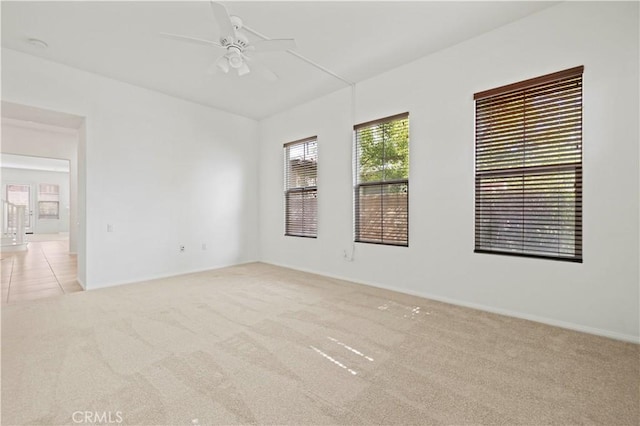 carpeted spare room featuring ceiling fan