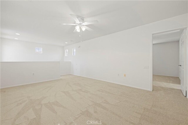 carpeted spare room featuring ceiling fan