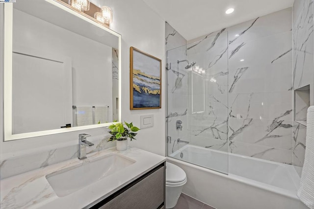 full bathroom featuring tiled shower / bath combo, vanity, and toilet