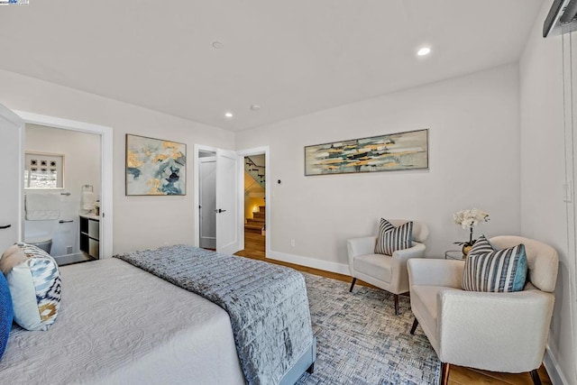 bedroom featuring hardwood / wood-style flooring and ensuite bath