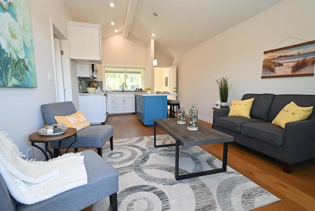 living room featuring vaulted ceiling with beams, dark hardwood / wood-style floors, and sink