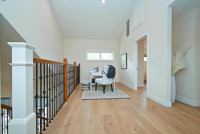 living area featuring light wood-type flooring and a towering ceiling