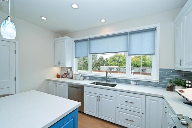 kitchen with white cabinets, dishwasher, decorative light fixtures, and sink