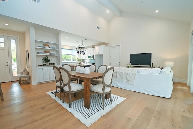 dining area featuring light wood-type flooring, beamed ceiling, and plenty of natural light