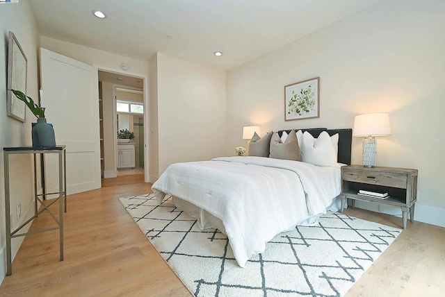 bedroom featuring light hardwood / wood-style floors and ensuite bathroom