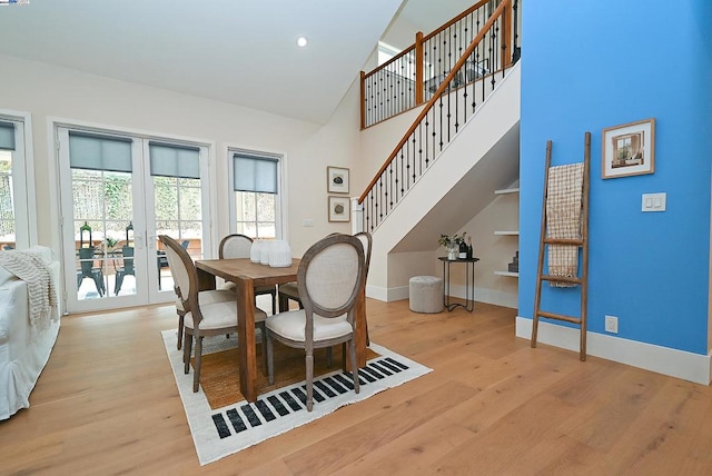 dining space featuring light hardwood / wood-style flooring, french doors, and high vaulted ceiling