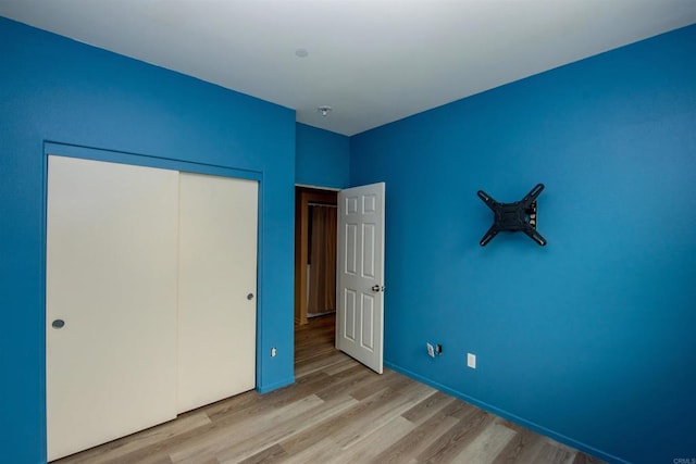 unfurnished bedroom featuring a closet and light wood-type flooring