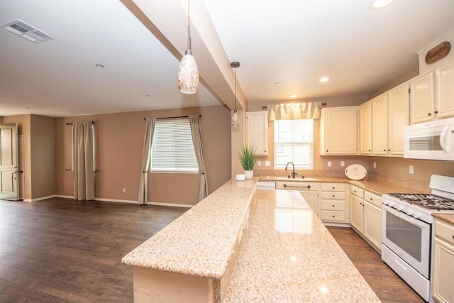 kitchen with white appliances, sink, dark hardwood / wood-style flooring, hanging light fixtures, and light stone counters