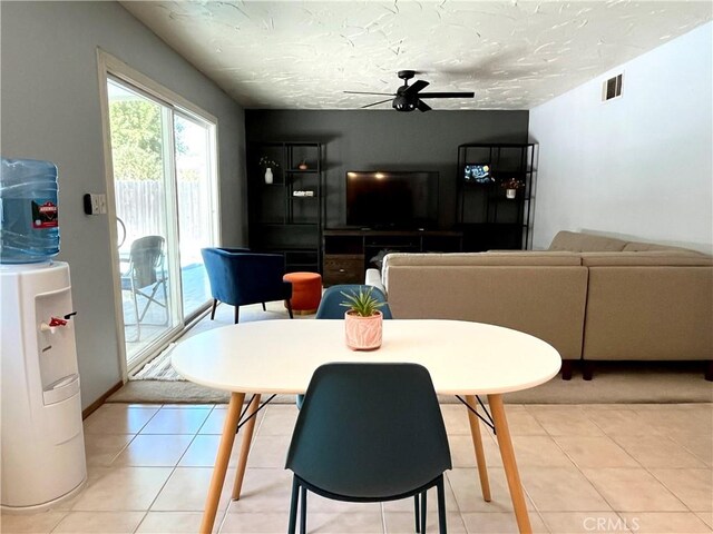 dining space with ceiling fan, a textured ceiling, and tile patterned floors