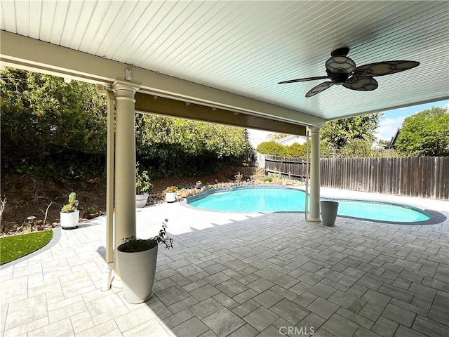view of swimming pool with a fenced backyard, a ceiling fan, a fenced in pool, and a patio area