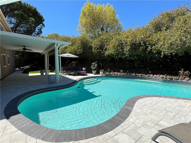 view of swimming pool with ceiling fan and a patio area