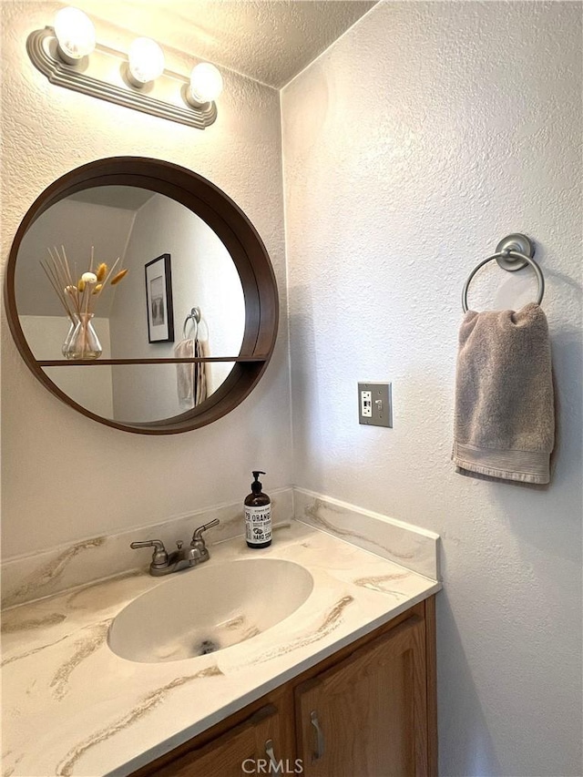 bathroom featuring vanity and a textured wall