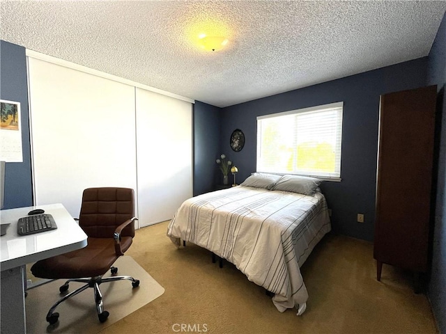 bedroom featuring a closet, a textured ceiling, and carpet