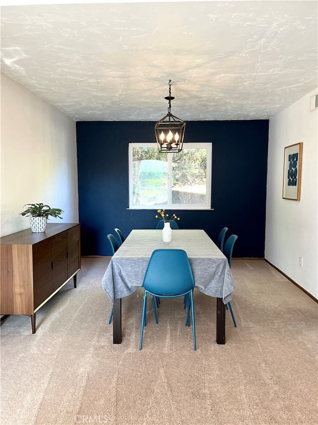 dining space featuring an inviting chandelier, a textured ceiling, and light colored carpet