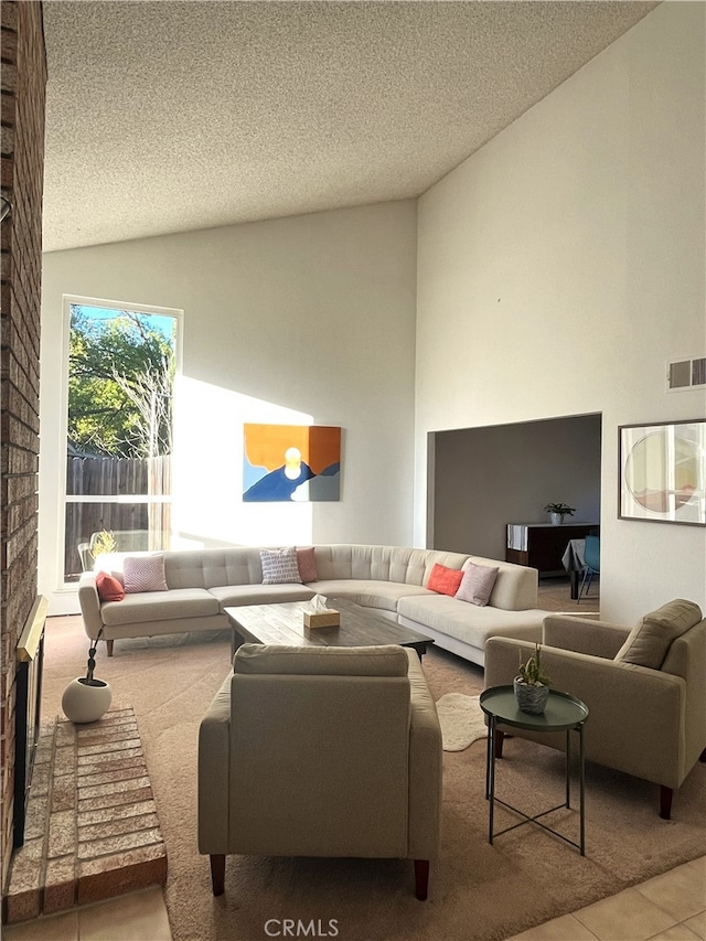 tiled living room featuring a textured ceiling, vaulted ceiling, and a brick fireplace